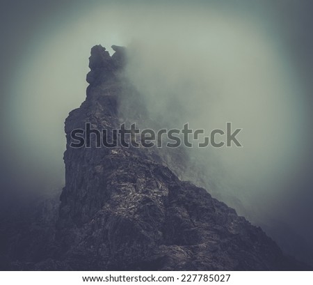 Fog over high mountain peak