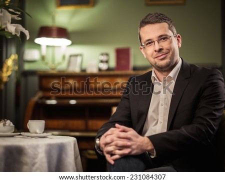 Middle-aged man behind table in luxury vintage style interior