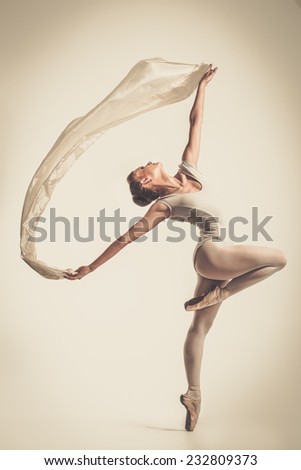 Young ballerina dancing with piece of silk fabric