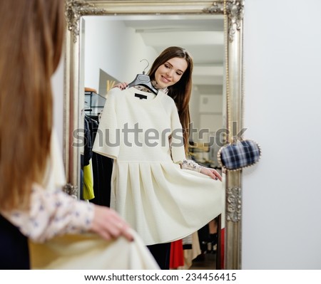 Young woman choosing clothes in a showroom 