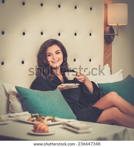 Beautiful woman having breakfast in a hotel room