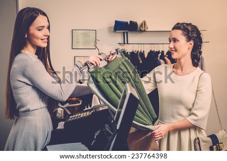 Happy woman customer paying in fashion showroom