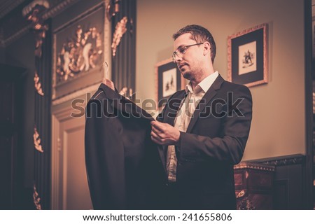Middle-aged man looking at suit on a hanger
