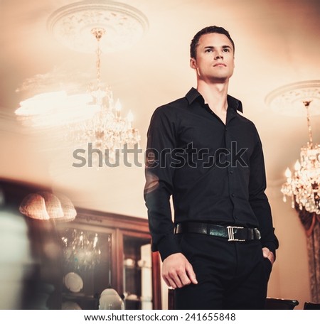 Handsome young well-dressed man in luxury house interior