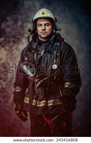 Firefighter with helmet and axe in a smoke