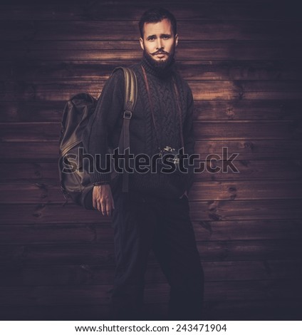 Handsome man wearing cardigan with backpack and vintage camera