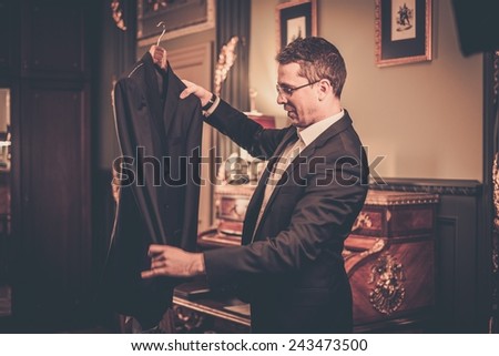 Middle-aged man looking at suit on a hanger