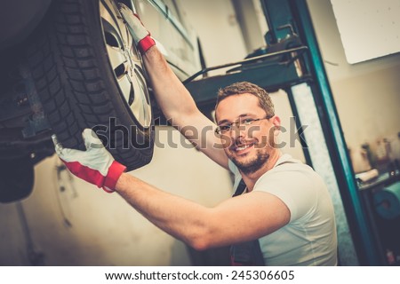 Mechanic checking wheel bearings in a car workshop