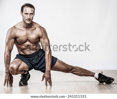 Handsome muscular man doing stretching exercise