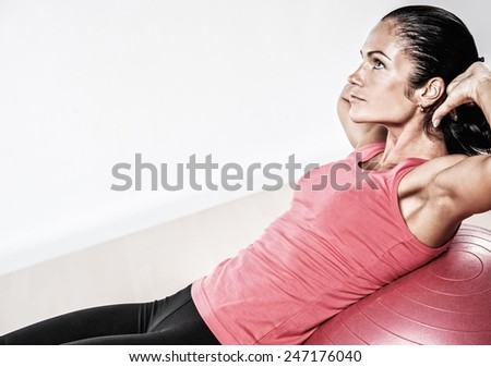 Athletic woman doing exercise on a fitness ball