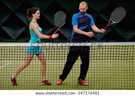 Woman player and her coach practicing on a tennis court
