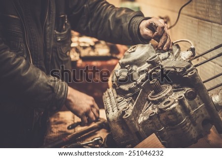 Mechanic working with with motorcycle engine in a workshop
