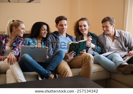 Group of multi ethnic young students preparing for exams in home interior