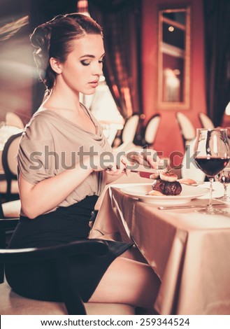 Beautiful young woman eating alone in a restaurant