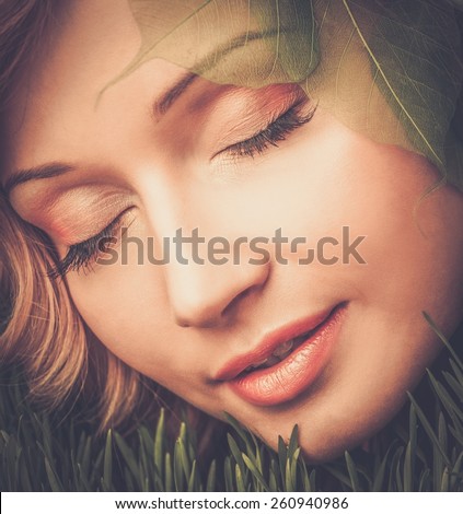 Dreaming young woman lying on a fresh spring grass