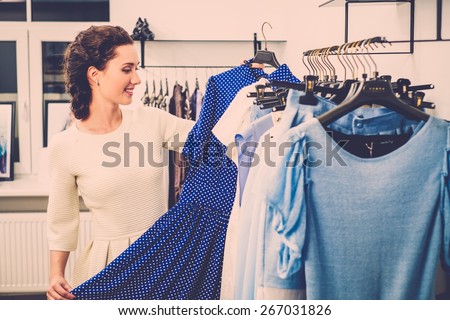 Young woman choosing clothes on a rack in a showroom