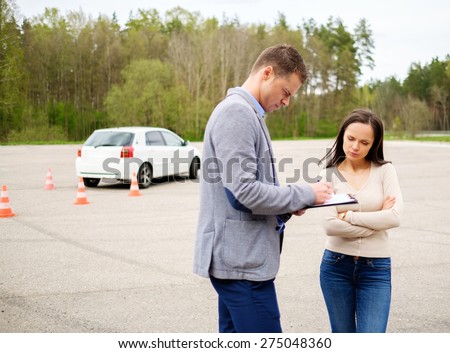 Driving instructor and woman student in examination area