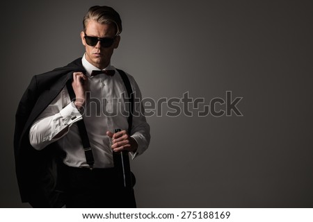 Sharp dressed man in black suit with bottle of wine