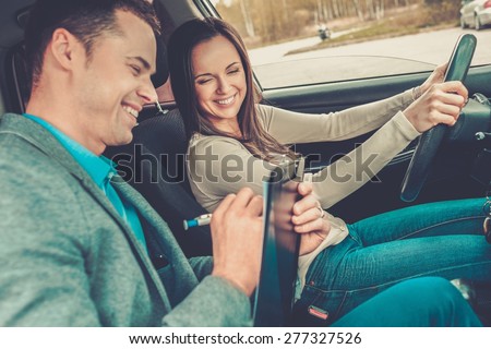 Driving instructor and woman student in examination car