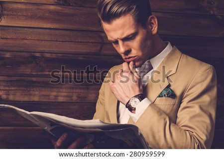 Stylish man with newspaper in rural cottage interior