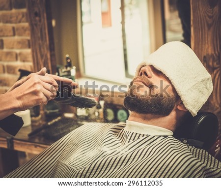 Hairstylist applying  beard powder in barber shop