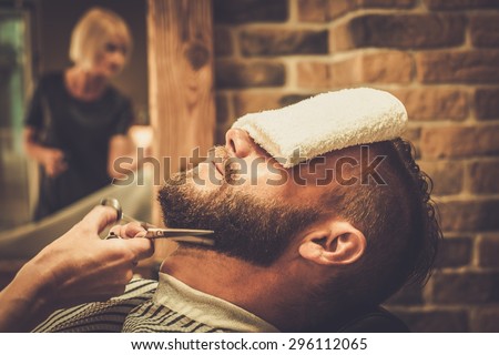 Client during beard and moustache grooming in barber shop