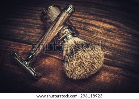 Safety razor and shaving brush on a wooden background