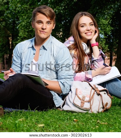 Students couple preparing for final exams in a city park