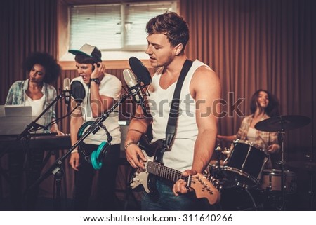 Multiracial music band performing in a recording studio