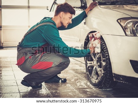 Man worker washing car\'s alloy rims on a car wash