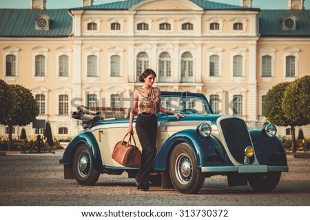 Beautiful lady with bag near classic convertible