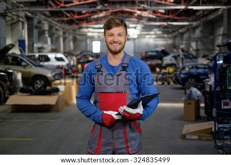 Cheerful serviceman in a car workshop