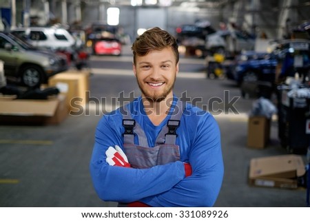 Cheerful serviceman in a car workshop