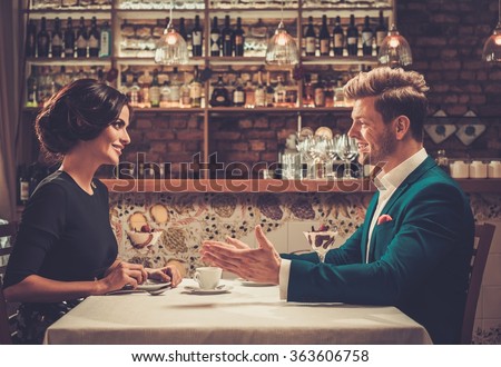Stylish wealthy couple having desert and coffee together in a restaurant.