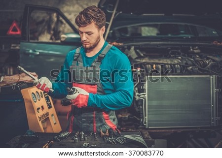 Mechanic with pneumatic tool in a workshop