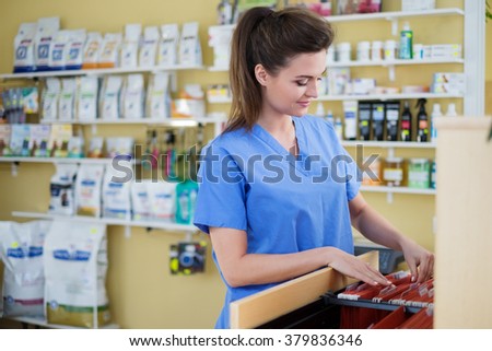 Portrait of beautiful nurse with folder at veterinary clinic.