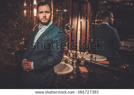 Confident well-dressed man in luxury bathroom interior.