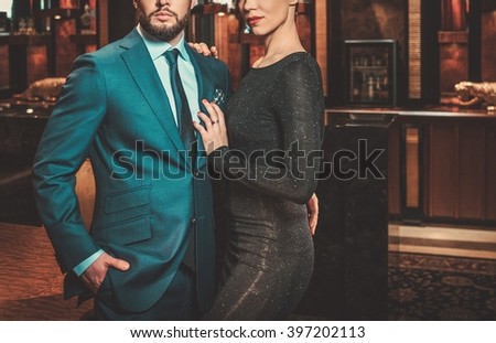Well-dressed couple in luxury apartment interior.
