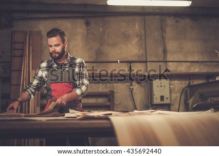 Carpenter doing his job in carpentry workshop.