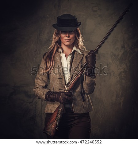 Lady with shotgun from wild west on dark background.