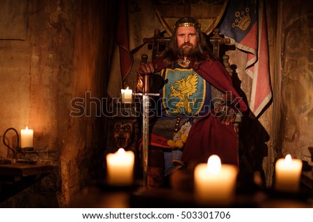 Old medieval king on the throne in ancient castle interior.