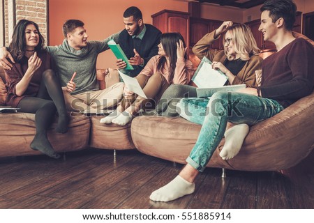 Group of multi ethnic young students preparing for exams in home interior.