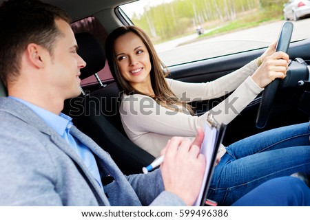 Driving instructor and woman student in examination car.