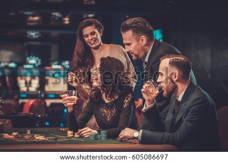 Upper class friends gambling in a casino.