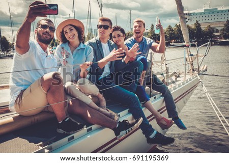 Happy friends taking selfie on a yacht