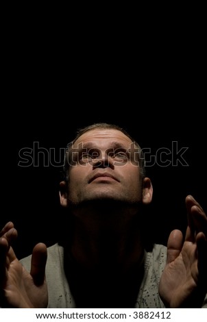Praying man isolated on black