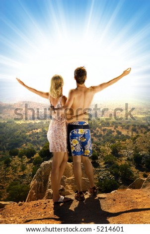 An attractive couple relaxing in high mountains and watching sunrise