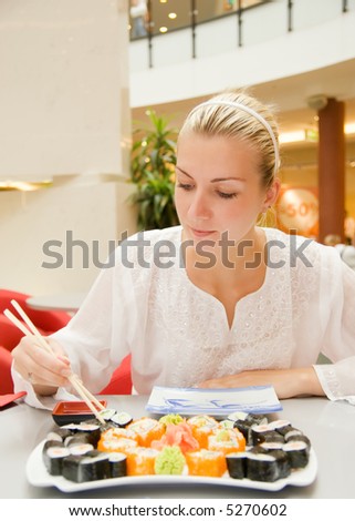 Girl eats sushi in a restaurant