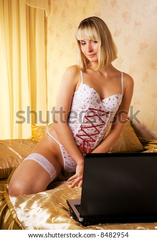 Young woman on a bed with laptop