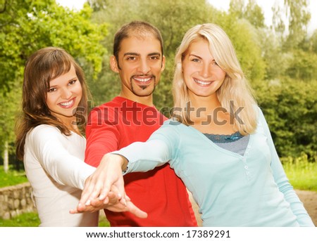 Group of young people put hands on top of each other